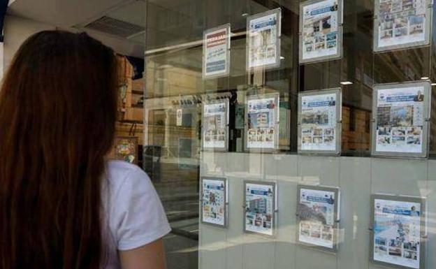 A woman observes the offer of flats in a real estate agency, in a file image.