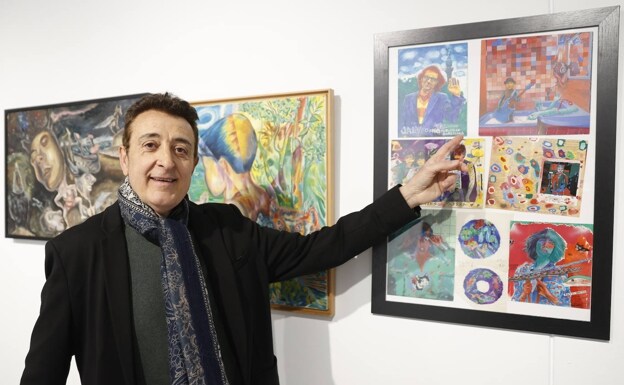The artist shows one of the paintings from his exhibition.  / 