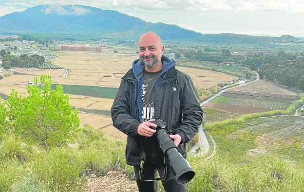Juan José Nicolás equipped with his camera in the middle of the mountains. 
