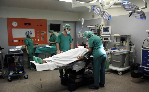 Health workers attend to a patient in the operating room, in a file image. 
