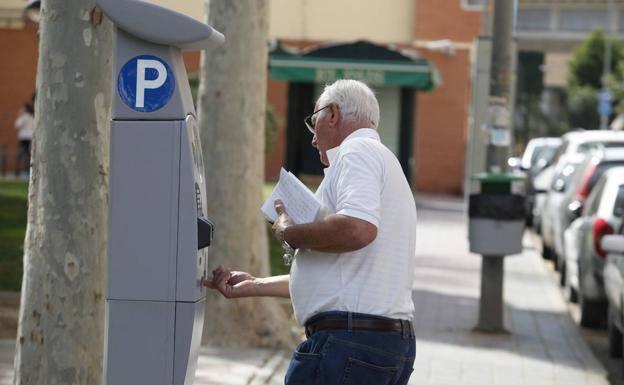 A resident of Murcia pays the parking fee in the blue zone. 